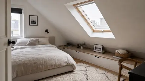 Petite chambre sous combles avec lit sous pente et rangements bas