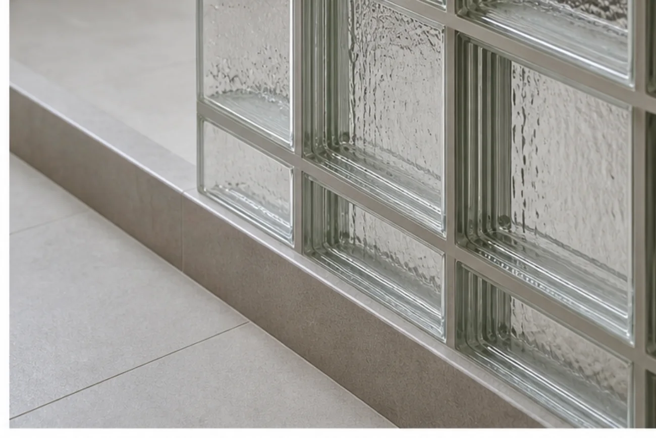 Détail de briques de verre avec joints discrets au pied d’une douche